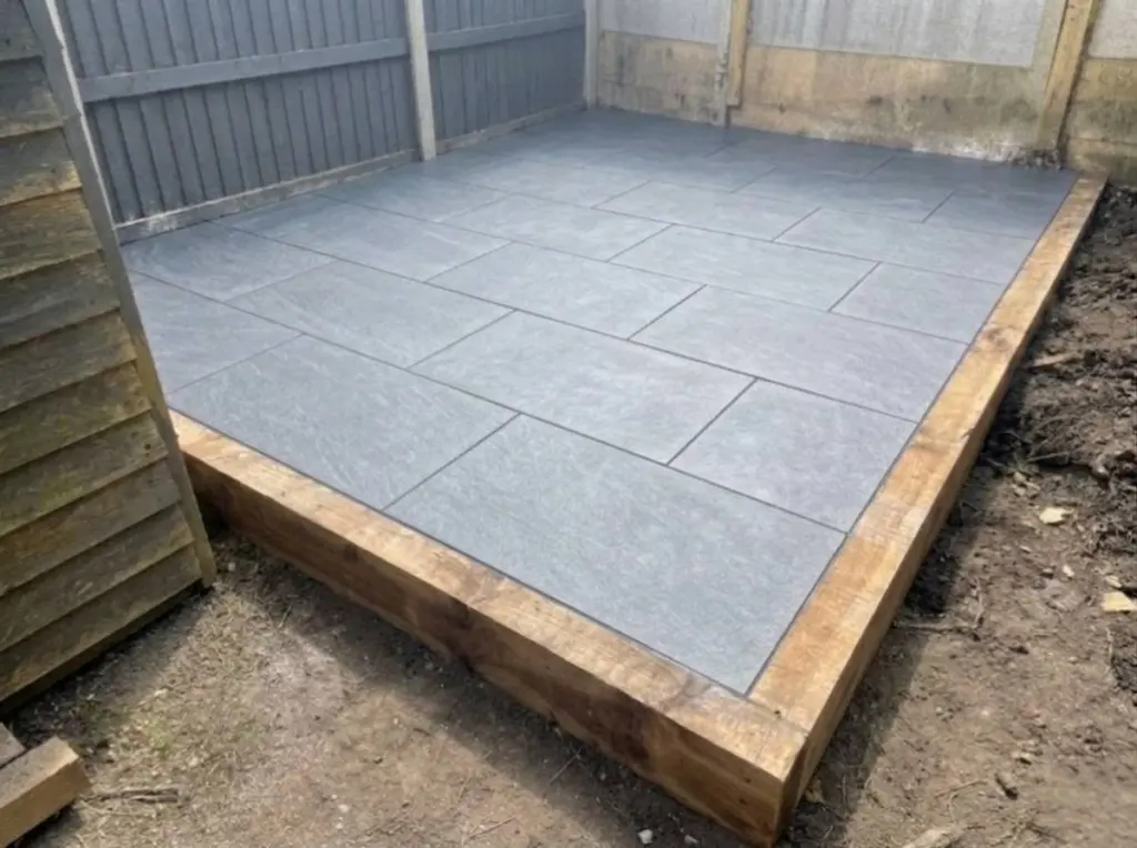 Grey porcelain patio framed with timber sleepers