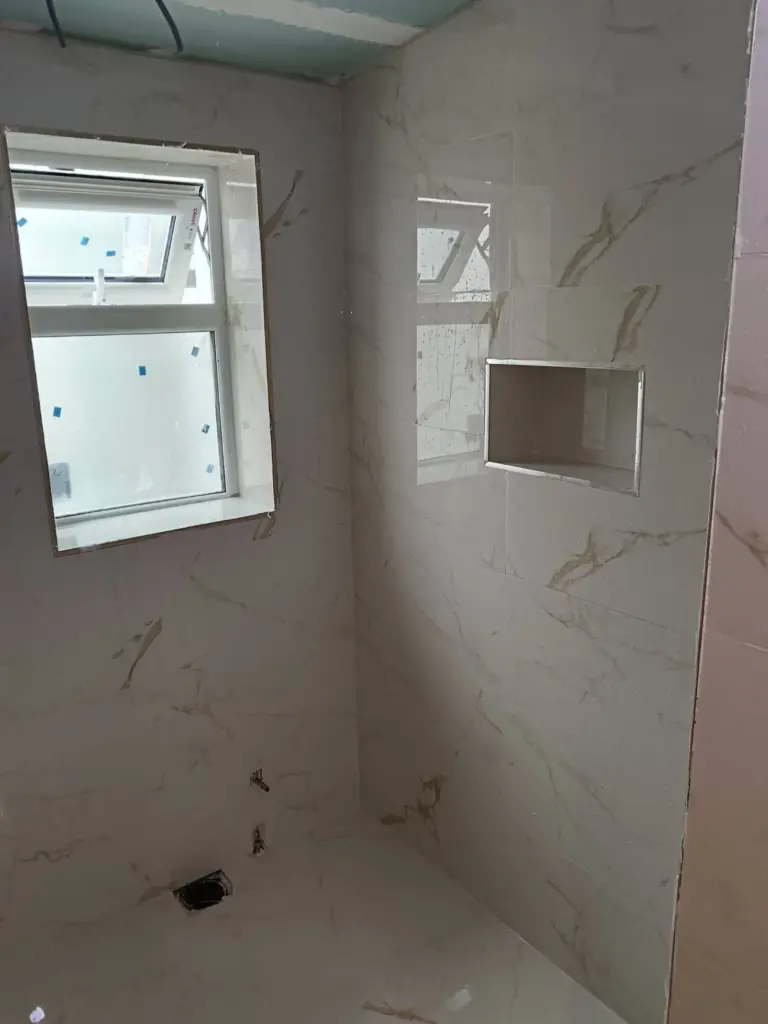 Marble-effect bathroom with recessed shower niche
